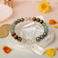 Beaded bracelet with a 'FREE' tag on a decorative background with flowers and coins.